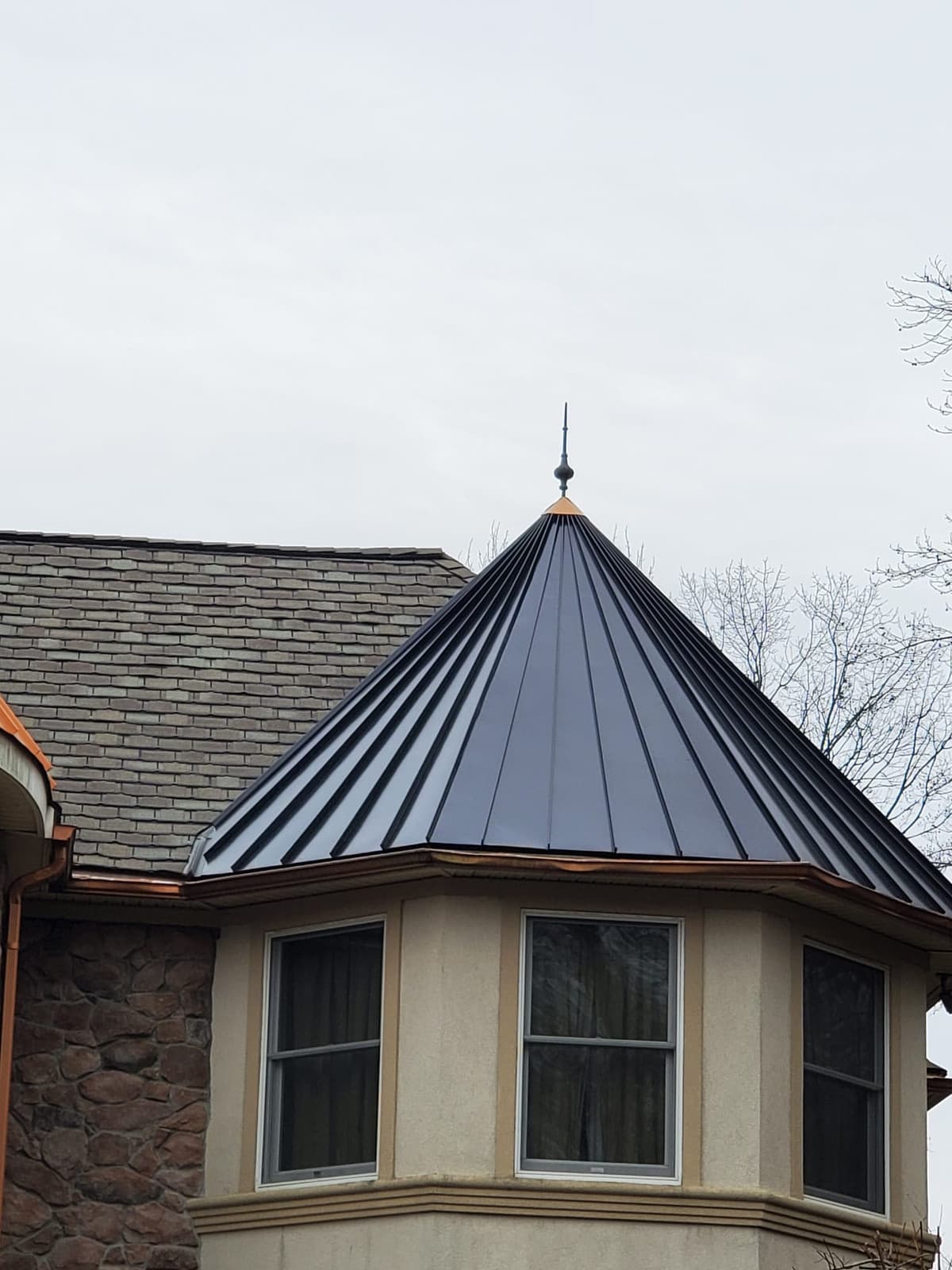 Black standing-seam metal roof on a stone-and-stucco turret in Woodland Park, NJ