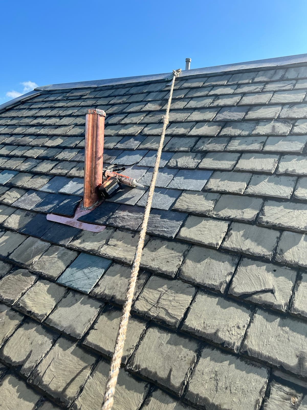 Close-up of copper chimney flashing on a slate roof — Zubar Roofing premium repair detail in New Jersey.