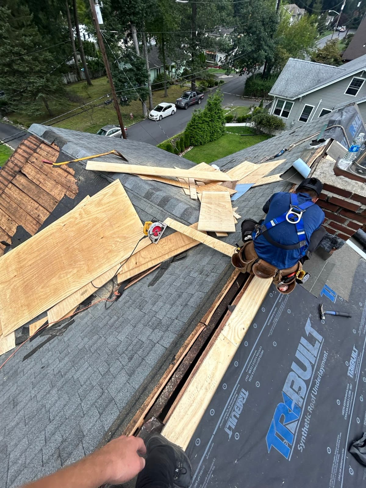 Zubar Roofing installer replacing damaged roof decking and laying new underlayment on a New Jersey home.