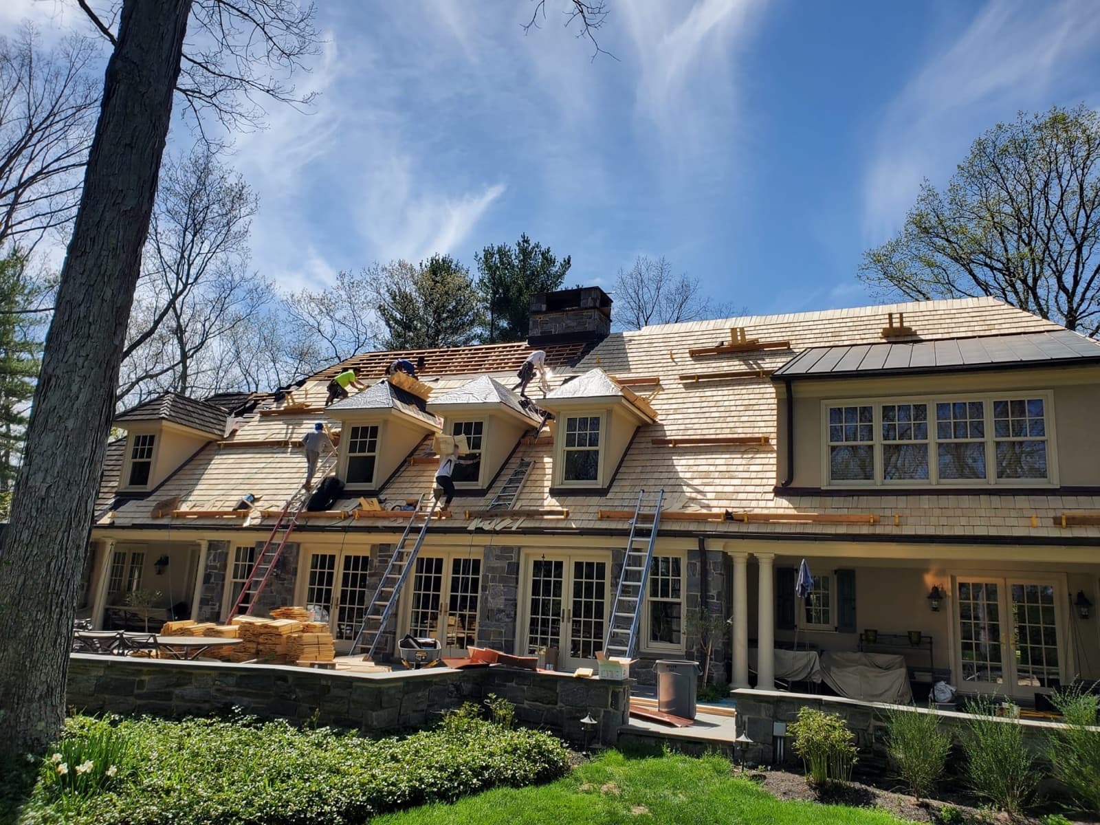 Full roof replacement on a New Jersey luxury home — Zubar Roofing crew installing cedar shake over a complete tear-off.