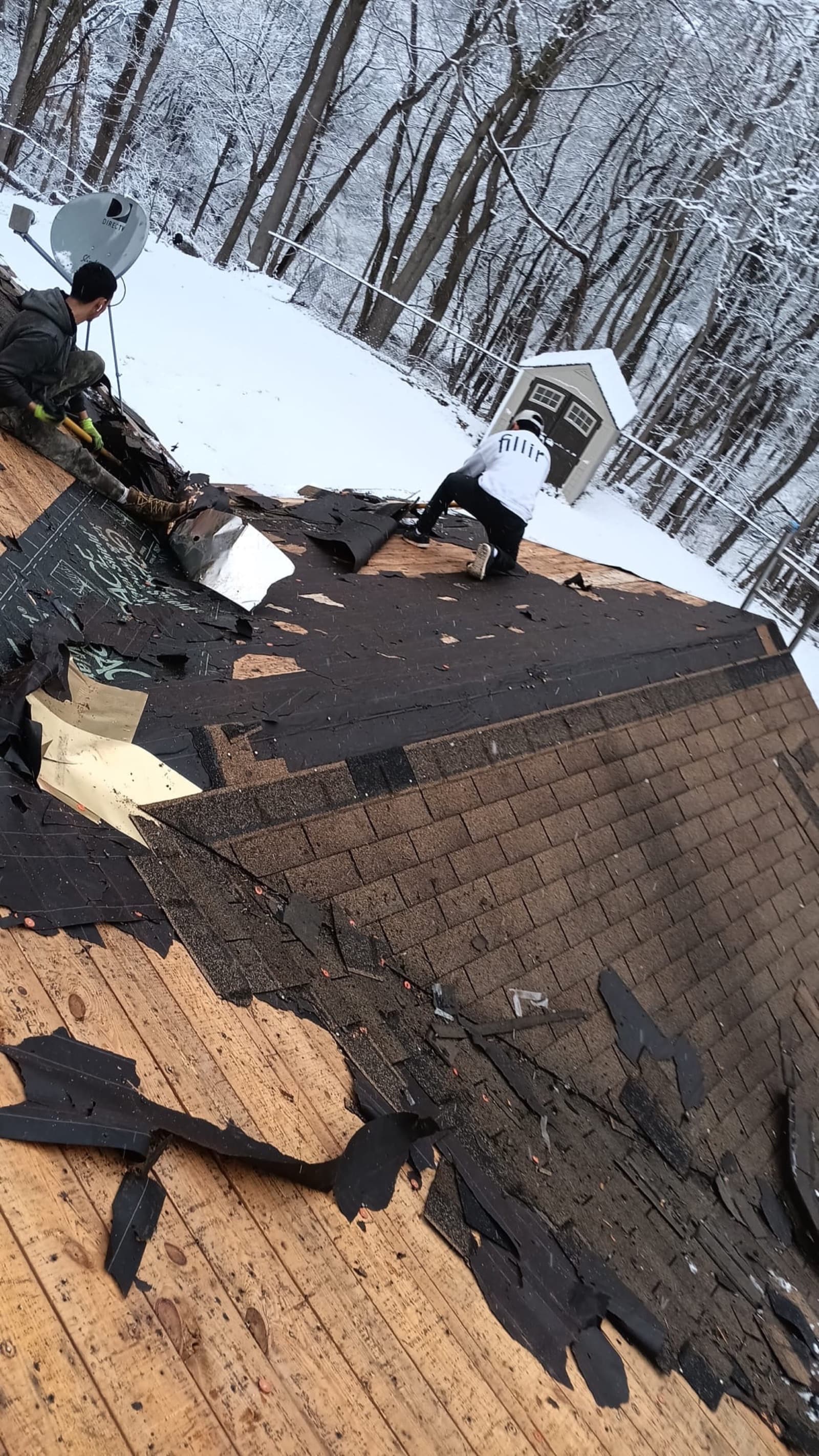 Emergency storm damage roof tear-off in winter — Zubar Roofing crew documenting and replacing wind-damaged shingles in New Jersey.